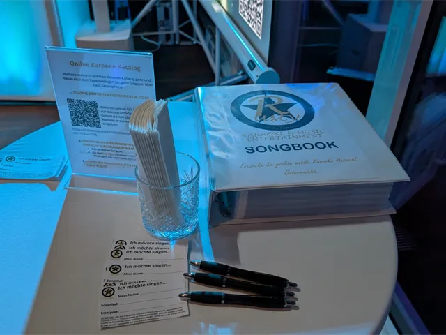 Karaoke-Songbook, Aufsteller zum Online-Karaoke-Katalog und Anmeldezettel für die Sänger bei einer Weihnachtsfeier im Techgate Wien