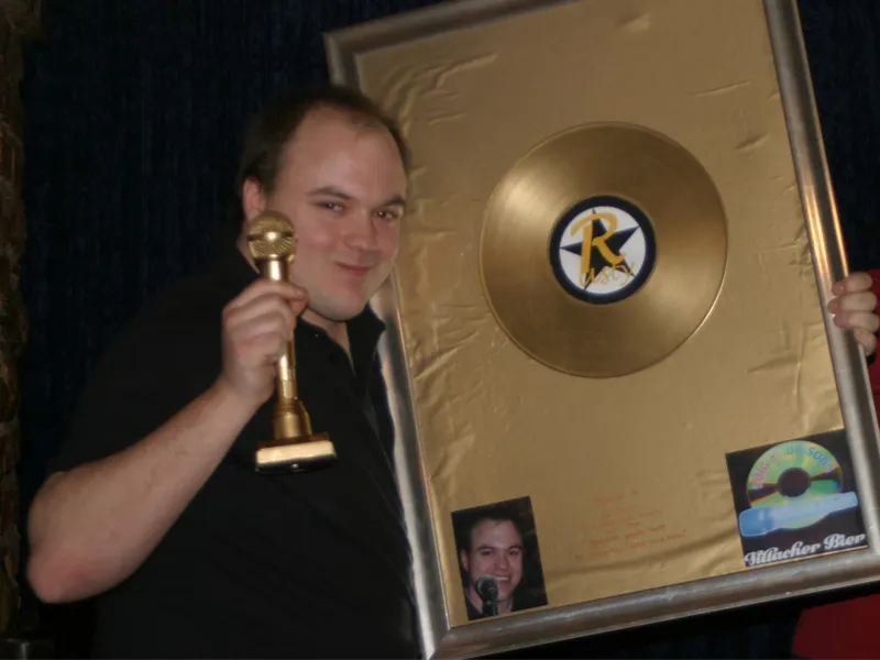 Kurt Steinbach alias DJ Rusty mit goldenem Mikrofon und goldener Schallplatte an seinem letzten Abend als Chef-DJ im „Sing Your Song“ in Wien, 2013